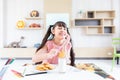 happy young asian girl eat milk cookie biscuit with dairy fresh milk for breakfast in morning after finish homework from school