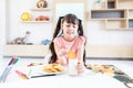 happy young asian girl eat milk cookie biscuit with dairy fresh milk for breakfast in morning after finish homework from school