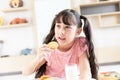 happy young asian girl eat milk cookie biscuit with dairy fresh milk for breakfast in morning before go to study at school