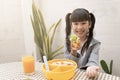 Happy young asian girl eating breakfast and orange juice on the table at home. Royalty Free Stock Photo