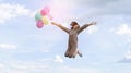 Happy young Asian girl holding colorful balloons jumping with blue sky background Royalty Free Stock Photo