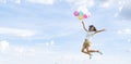 Happy young Asian girl holding colorful balloons jumping with blue sky background Royalty Free Stock Photo