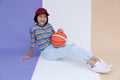 Happy young asian girl palying basketball with pastel background