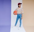 Happy young asian girl palying basketball with pastel background