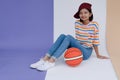 Happy young asian girl palying basketball with pastel background