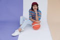 Happy young asian girl palying basketball with pastel background