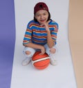 Happy young asian girl palying basketball with pastel background