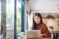 Asian girl working at a coffee shop with a laptop Royalty Free Stock Photo