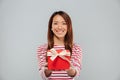 Happy young asian lady holding gift. Royalty Free Stock Photo