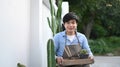 A happy young Asian man hands holding a tray with cactus. Royalty Free Stock Photo