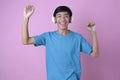 Happy Young Asian man listening to music with wireless headphone and dancing