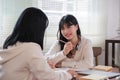 A happy young Asian man and a pretty girl are working on a laptop together, working on a co-project, sharing ideas and Royalty Free Stock Photo