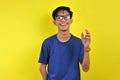 Happy Young Asian man smiling wearing glasses, isolated on yellow Royalty Free Stock Photo