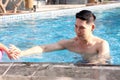 Happy young Asian man swimming in blue water pool, relaxing swimmer male have fun activity in summer. Swimming for exercise, swim Royalty Free Stock Photo