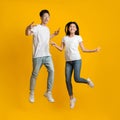 Happy young asian man and woman jumping up while posing Royalty Free Stock Photo