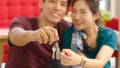 Happy young asian married couple holding key while relocation into new home on moving day, celebrating moving to new home concept Royalty Free Stock Photo