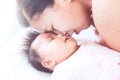 Happy young asian mother kissing her newborn baby girl with love Royalty Free Stock Photo