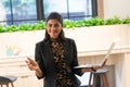 Happy young Asian saleswoman holding laptop. Smiling business woman agent broker, Standing in the modern office. Successful Royalty Free Stock Photo