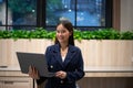 Happy young Asian saleswoman holding laptop. Smiling business woman agent broker, Standing in the modern office. Successful Royalty Free Stock Photo