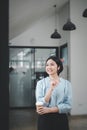 Happy young Asian saleswoman looking out the window. Smiling woman executive manager, Royalty Free Stock Photo