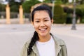 Happy young asian teen girl smiling at camera standing at city street Royalty Free Stock Photo