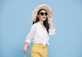 Happy young Asian tourist woman holding baggage going to travel on holidays isolated on blue background Royalty Free Stock Photo