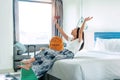 Happy young Asian traveler woman relax on bed in hotel room. Travel alone, summer and holiday concept Royalty Free Stock Photo