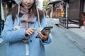 Happy young Asian traveler woman using smart phone, close up Royalty Free Stock Photo