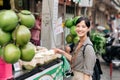 Happy young Asian woman backpack traveler stand in front of coconut juice shop at China town street food market in Bangkok,