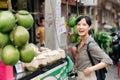 Happy young Asian woman backpack traveler stand in front of coconut juice shop at China town street food market in Bangkok,