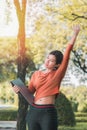 Happy young asian woman be smile working with her laptop and hand up on a bench in the park outdoors on vacation time Royalty Free Stock Photo