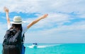 Happy young Asian woman in casual style fashion with straw hat and backpack. Relax and enjoy holiday at tropical paradise beach. Royalty Free Stock Photo