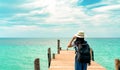 Happy young Asian woman in casual style fashion with straw hat and backpack. Relax and enjoy holiday at tropical paradise beach. Royalty Free Stock Photo