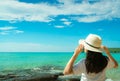 Happy young Asian woman in casual style fashion with straw hat stand at sea beach of resort in summer vacation . Relaxing Royalty Free Stock Photo