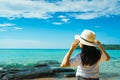 Happy young Asian woman in casual style fashion with straw hat stand at sea beach of resort in summer vacation . Relaxing Royalty Free Stock Photo