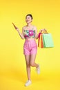 happy young asian woman celebrating with mobile phone and holding shopping bags Royalty Free Stock Photo