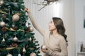 Happy young asian woman decorating christmas tree at home Royalty Free Stock Photo