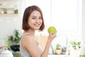 Happy Young Asian Woman Eating Green Apple on Kitchen. Diet. Die Royalty Free Stock Photo