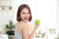 Happy Young Asian Woman Eating Green Apple on Kitchen. Diet. Die Royalty Free Stock Photo