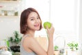 Happy Young Asian Woman Eating Green Apple on Kitchen. Diet. Die Royalty Free Stock Photo