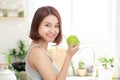 Happy Young Asian Woman Eating Green Apple on Kitchen. Diet. Die Royalty Free Stock Photo