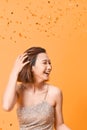 Happy young asian woman in fancy dress with sequins and confetti at party Royalty Free Stock Photo