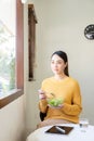 Happy young Asian woman with fresh vegetables and fresh fruits, healthy concept working lunch at home, Royalty Free Stock Photo