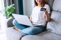 Happy young Asian woman holding credit card and using laptop computer. Businesswoman working at home office. Online shopping, e- Royalty Free Stock Photo