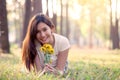 Happy young asian woman holding flower and lying down on grass Royalty Free Stock Photo