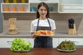 Happy young Asian woman holding fresh apple fruit in the modern kitchen Royalty Free Stock Photo