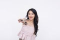 A happy young asian woman holding a pair of scissors, motioning to cut hair. A novice hairdresser. Isolated on a white background Royalty Free Stock Photo