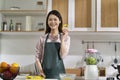 Portrait of a young asian housewife standing in kitchen Royalty Free Stock Photo