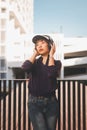 Happy young asian woman listening to music and having fun with headphones on the street. Royalty Free Stock Photo