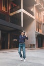 Happy young asian woman listening to music and having fun with headphones via smartphone on the street. Royalty Free Stock Photo